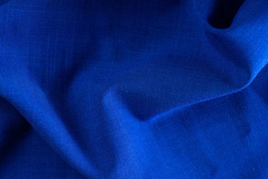 Texture of fabric for furniture upholstery. Wear and water resistant fabric in deep folds top view. Blue fabric texture closeup top view