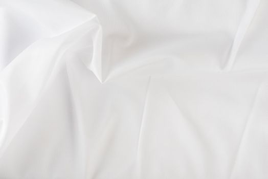 White wrinkled fabric. White fabric with large folds top view. For overlay texture or design