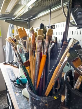 Artist's workshop with a paints, tables, easels and stretchers.