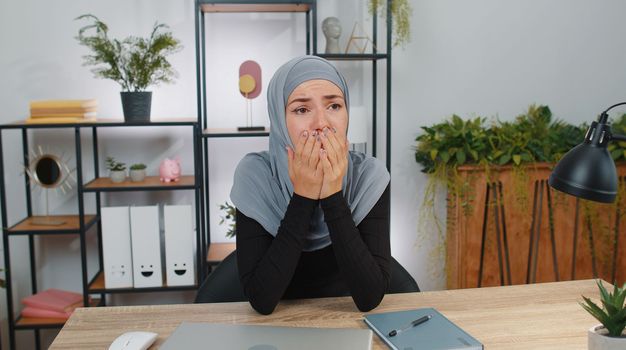 Sad young muslim business woman in hijab at home looks pensive thinks over life concerns or unrequited love, suffers from unfair situation. Girl problem break up depressed feeling bad annoyed, burnout