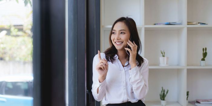 Asian businesswoman talking with client on mobile phone