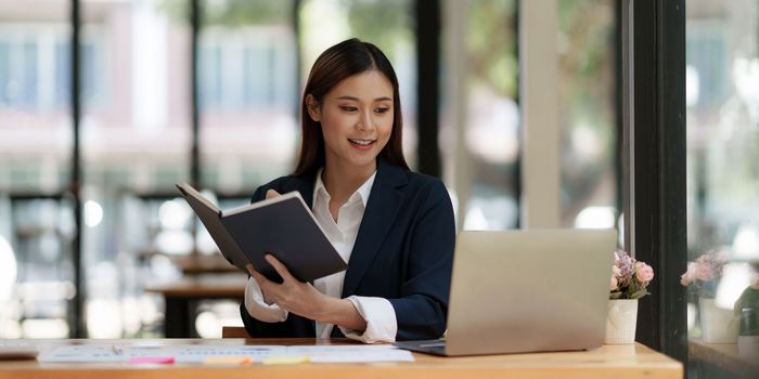 Beautiful asian businesswoman working on laptop in office. business finance concept.