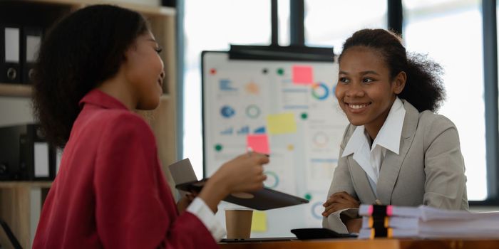 Smiling young African American businesswoman working with partner at office. finance concept.