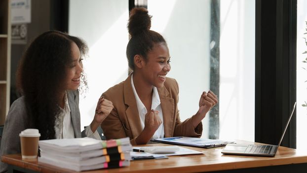 Excited young black businesswoman working with partner at office. finance concept.