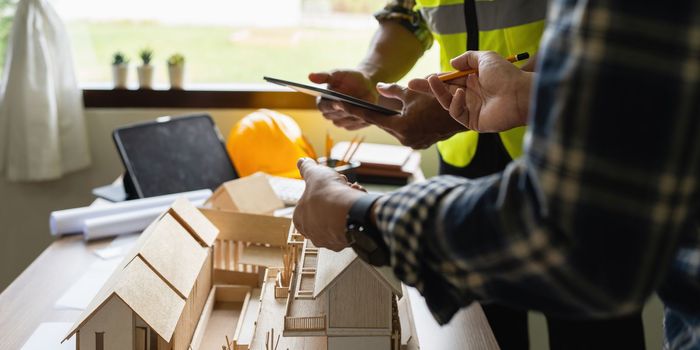 Architect man working with blueprints for architectural plan, engineer sketching a construction project concept.