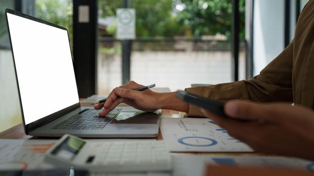 Asian businessman checking information while working with satisfaction on his laptop