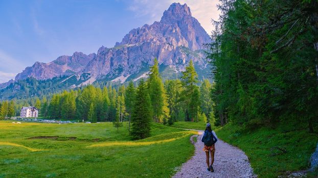woman hiking in the Italian Dolomites, a Girl hiking to Lago Di Sorapis in the Italian Dolomites Italy, woman mid age Asian walking in the mountains with a backpack