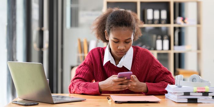 Portrait of Happy black woman reading phone message.