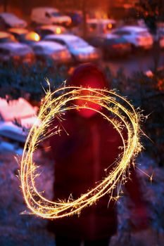 Child with a sparkler. Light painting in Christmas, winter time.