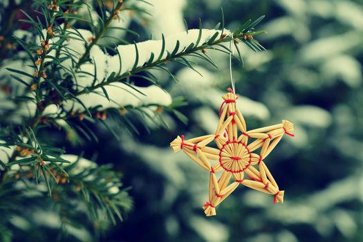 Christmas background with tree and natural old straw decoration. Winter holiday time with snow.