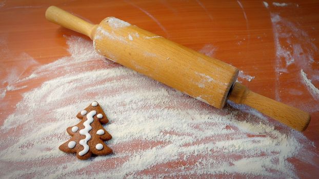 Homemade baking of Christmas cookies in the kitchen.
Gingerbread Christmas tree on table with flour and rolling pin.