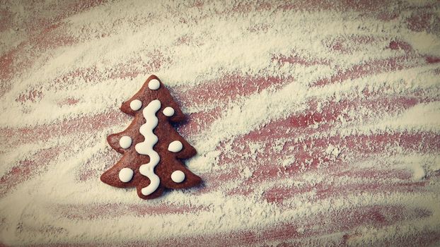 Homemade baking of Christmas cookies in the kitchen.
Gingerbread Christmas tree on table with flour and rolling pin.