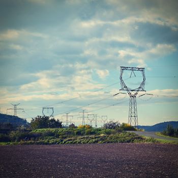 High voltage pylons - Blue sky with clouds and sun in nature. Concept for technology and industry. Further rising electricity and energy prices - the energy crisis caused by the war between Russia and Ukraine. 