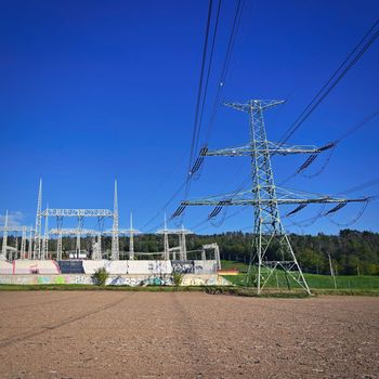 High voltage pylons - Blue sky with clouds and sun in nature. Concept for technology and industry. Further rising electricity and energy prices - the energy crisis caused by the war between Russia and Ukraine. 