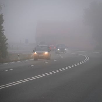 Bad weather driving - foggy hazy country road. Motorway - road traffic. Winter time. Autumn - fall. 