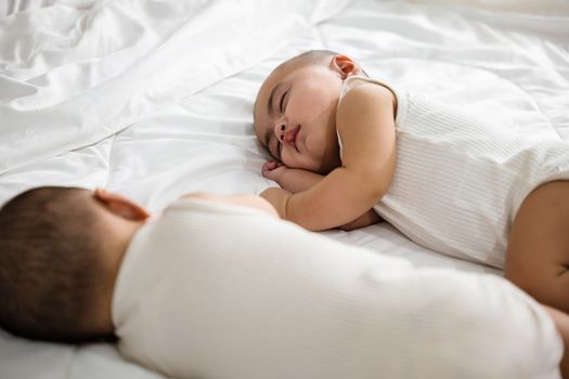 Asian two adorable twin babies boy, Happy childhood, Sleeping newborn identical boy twins on the bed on bedroom, family people infant