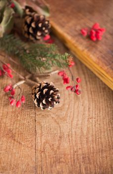 Christmas frame made of fir tree and magonia branches,cones,red viburnum berries on the dark wooden rustic background.Christmas background.Copy space for text, top view.