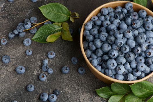 freshly picked blueberries close up with water drops on wood background