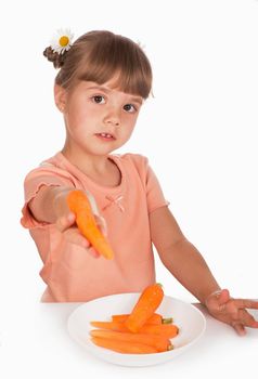 Cute little girl with the carrot, child offers a carrot on a white