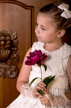 Girl holding peonies bouquet on wooden background