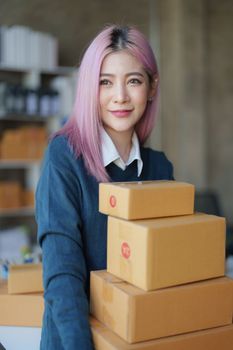 Startup small business entrepreneur of freelance Asian woman using a laptop with box Cheerful success online marketing packaging box and delivery SME idea concept.