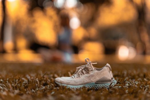 Sport shoes grass and female yoga on background.