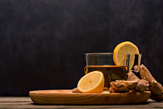 Cup of spiced tea with cinnamon sticks, anise star, lemon and jinger on rustic table