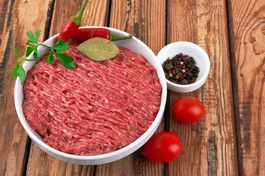 Fresh pork and beef minced meat on a wooden background.