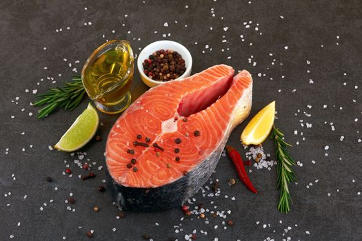 Salmon steak on a black background with spices