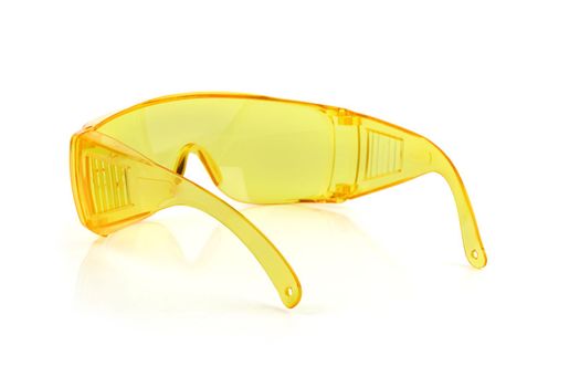Yellow plastic protective work glasses isolated on a white background