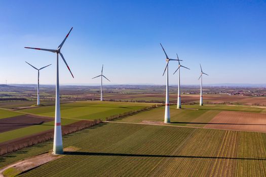 Wind turbines of a wind farm generate electricity for the energy transition as an aerial view, Germany