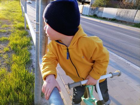 Adorable little toddler boy having fun on playground, child wearing yellow hoody jacket. High quality photo