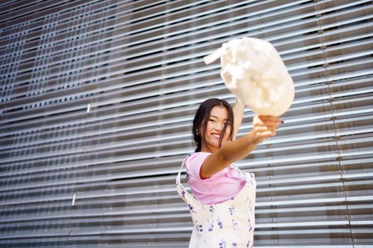 Happy young Asian female looking at camera smiling with happiness. Chinese student woman wearing casual clothes and cap.