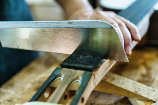 Spanish guitar maker, or luthier, working on a flamenco guitar. Unrecognizable craftsman marking the frets on the neck of a flamenco guitar, as part of the handcrafted manufacturing process.