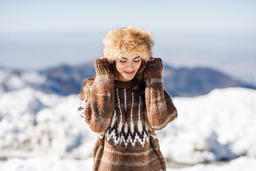 Funny woman enjoying the snowy mountains in winter, in Sierra Nevada, Granada, Spain. Female wearing winter clothes.