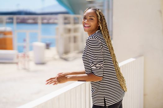 Beautiful young black woman enjoying the view of the seaport.