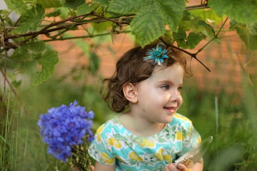 Cute little girl in autumn park holding bunch of yellow leaves. High quality photo