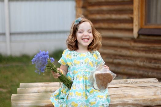 Cute little girl in autumn park holding bunch of yellow leaves. High quality photo