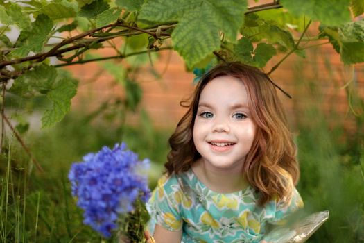 Cute little girl in autumn park holding bunch of yellow leaves. High quality photo