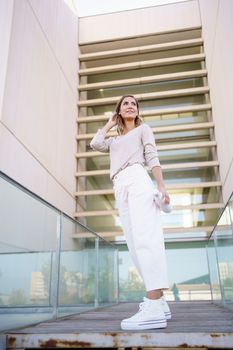 Caucasian woman carrying an eco-friendly ecological metal water bottle. Middle aged female in urban background.