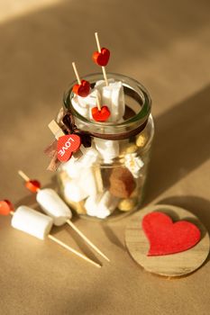 sweet gift for Valentine's Day with your own hands. A gift for the holiday made of heart-shaped candies and marshmallows.