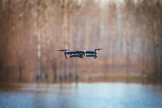 Drone take off from land and flying over the lake, for take aerial photo. Copy space.