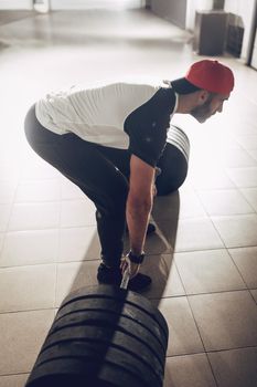 Young muscular man ready to deadlift exercise at the garage gym.