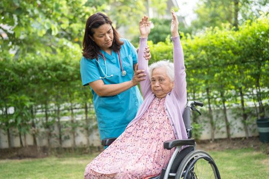 Doctor help Asian senior or elderly old lady woman patient exercise on wheelchair with happy in park.