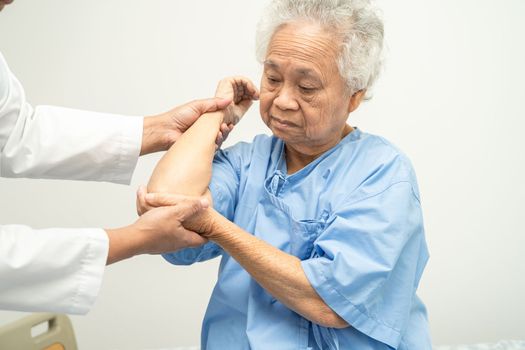 Asian senior or elderly old lady woman patient feel pain her elbow on bed in nursing hospital ward, healthy strong medical concept.