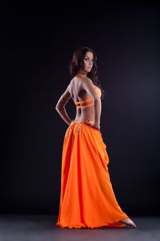 Full length portrait of oriental dancer in orange costume