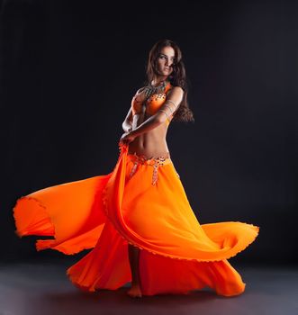 beauty young woman dance in orange veil arabic style costume