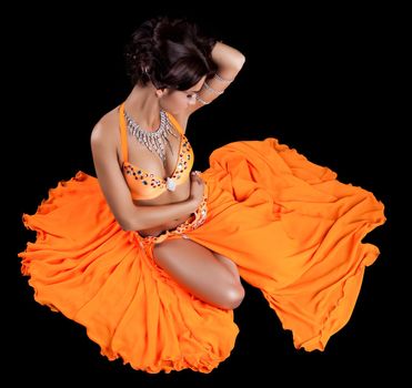 Studio portrait of pretty oriental dancer in orange costume