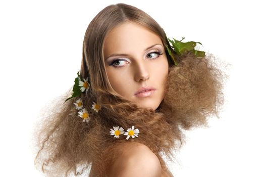 Beauty young girl spring portrait with leaves and camomile in hair