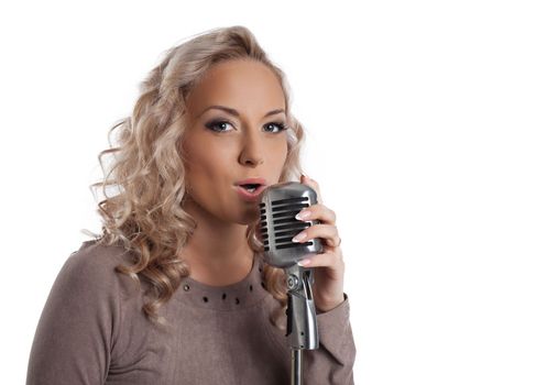 Pretty blonde woman with vintage microphone. Isolated on white